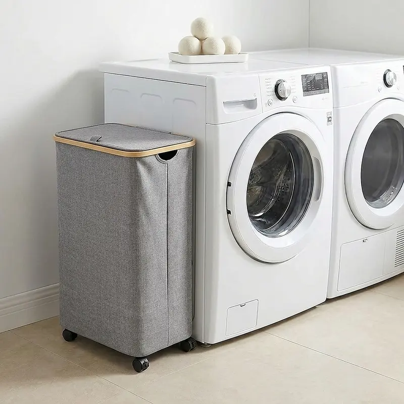 Slim rolling laundry hamper with a lid beside a washing machine
