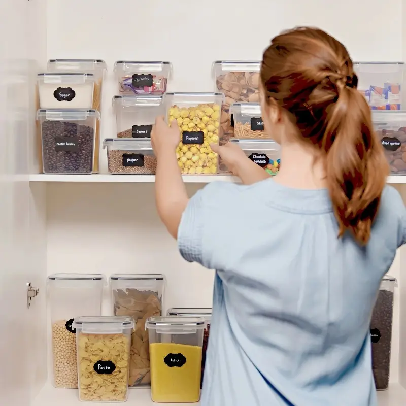 Plastic pantry jars with lids, labels and a pen on a shelf