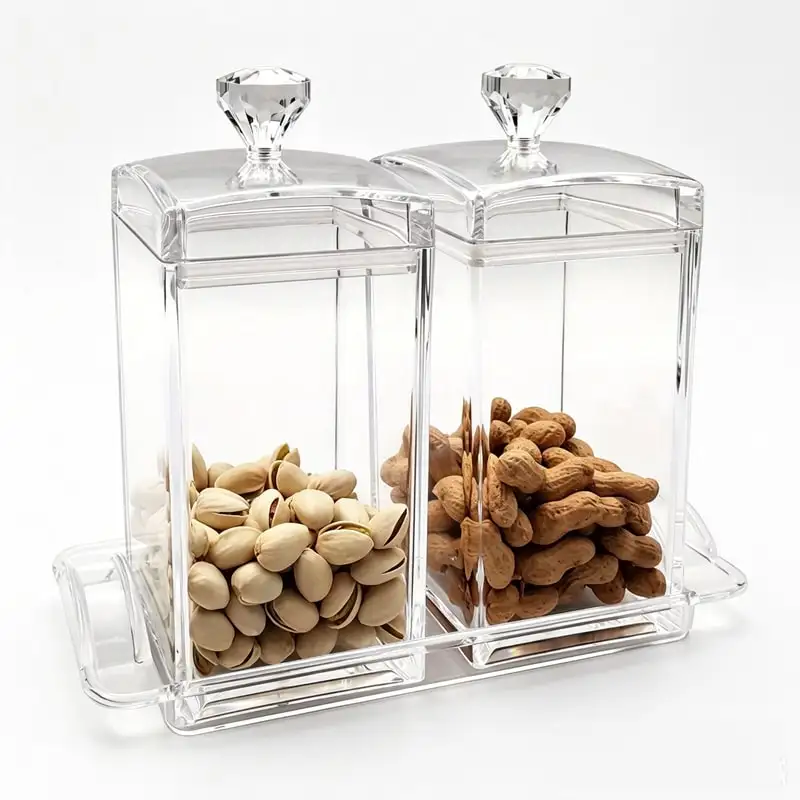 Two clear square acrylic canisters stacked with snacks inside
