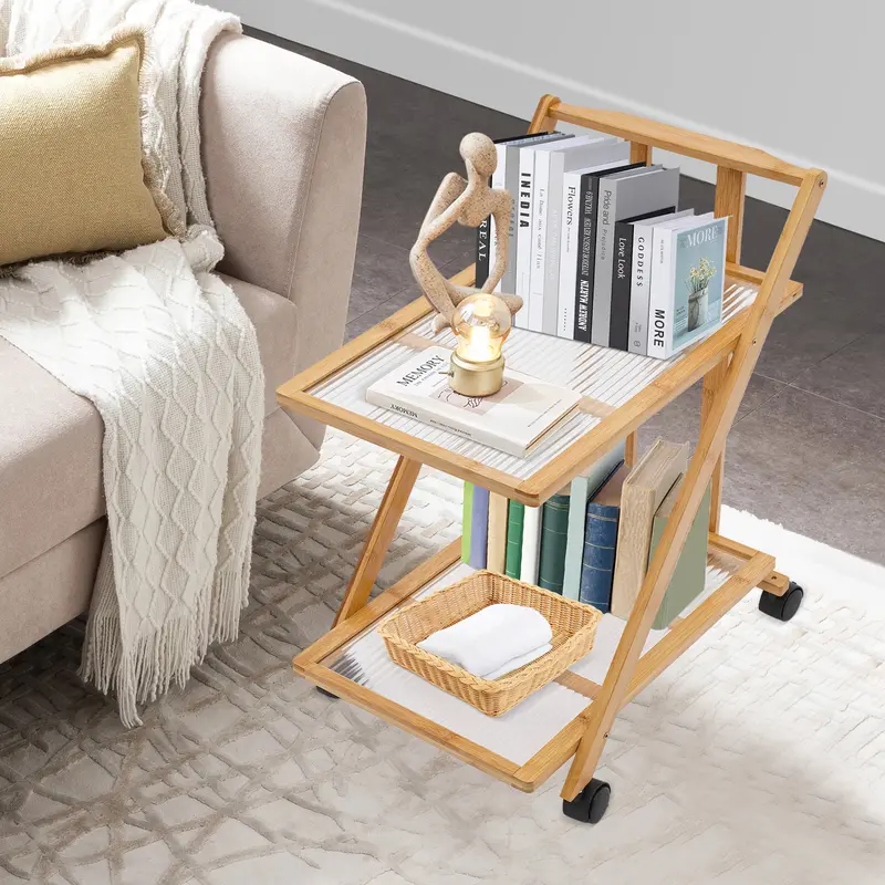 Two-tier folding bamboo cart with books beside a sofa