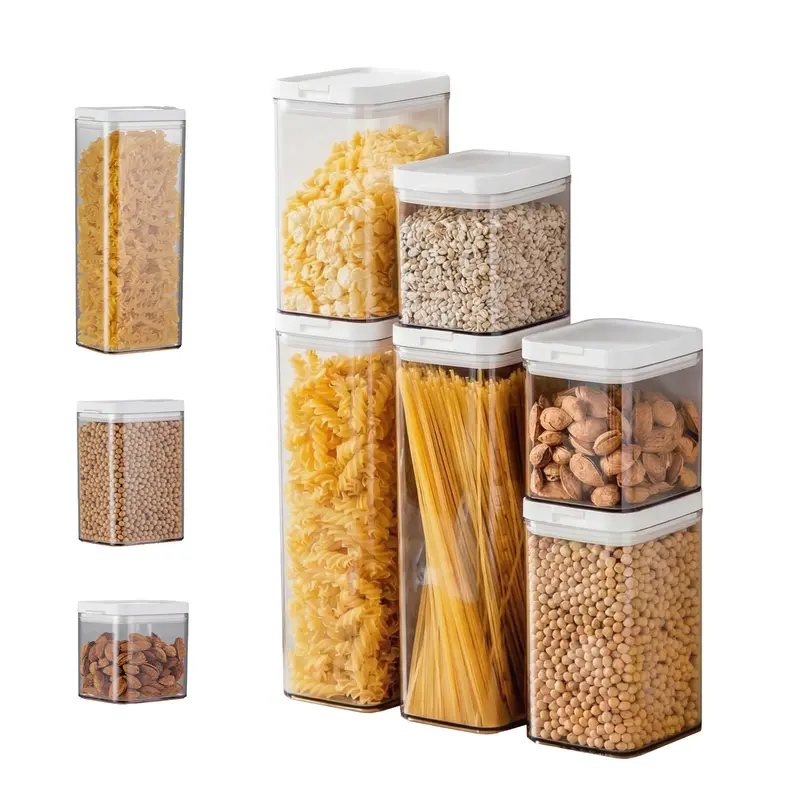 Six clear airtight pantry canisters with white lids holding dry food